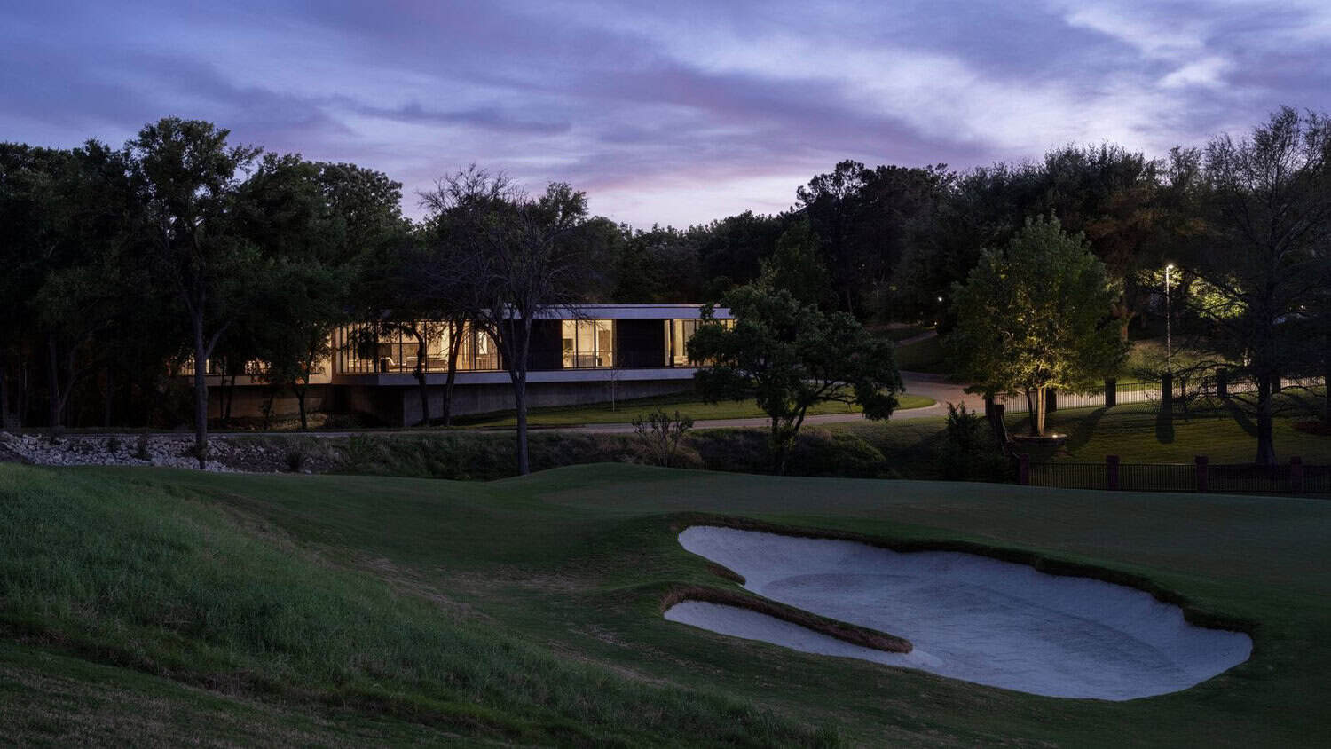 Dusk view of home overlooking golf course sand bunker