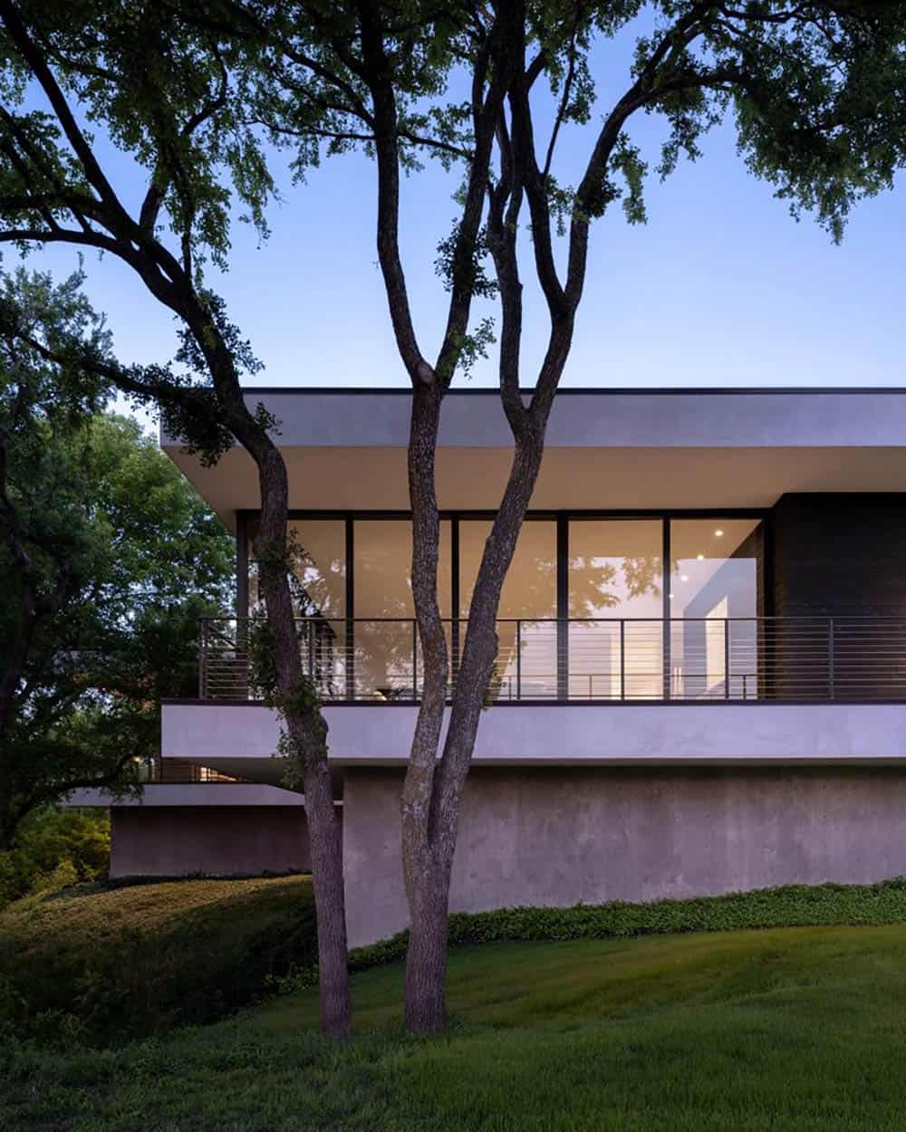 Home exterior framed by trees on elevated concrete foundation