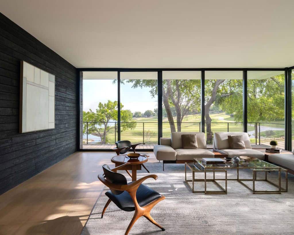Living room with golf course view through glass walls