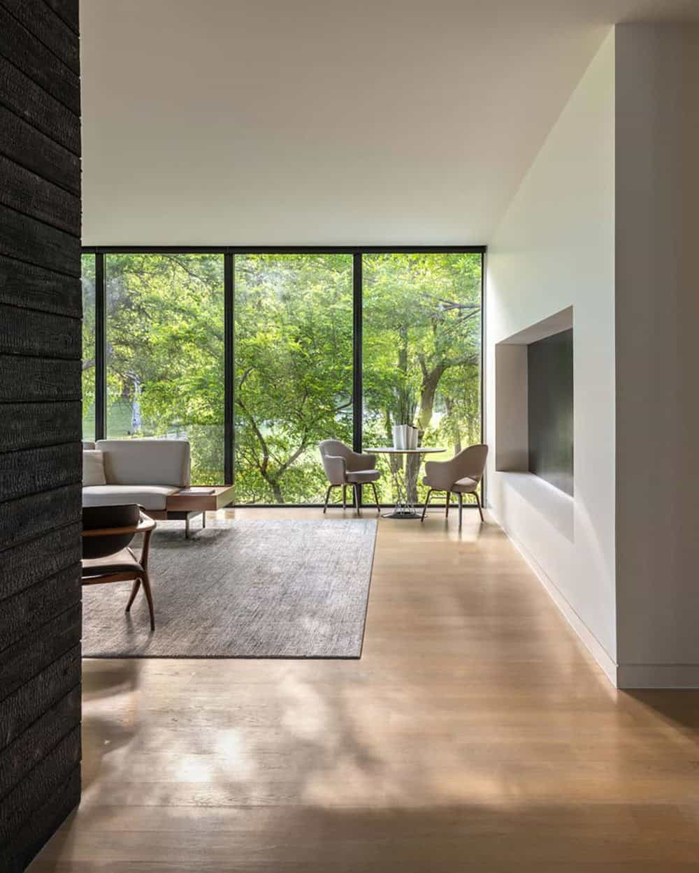 Living room seating area with wooded creek view
