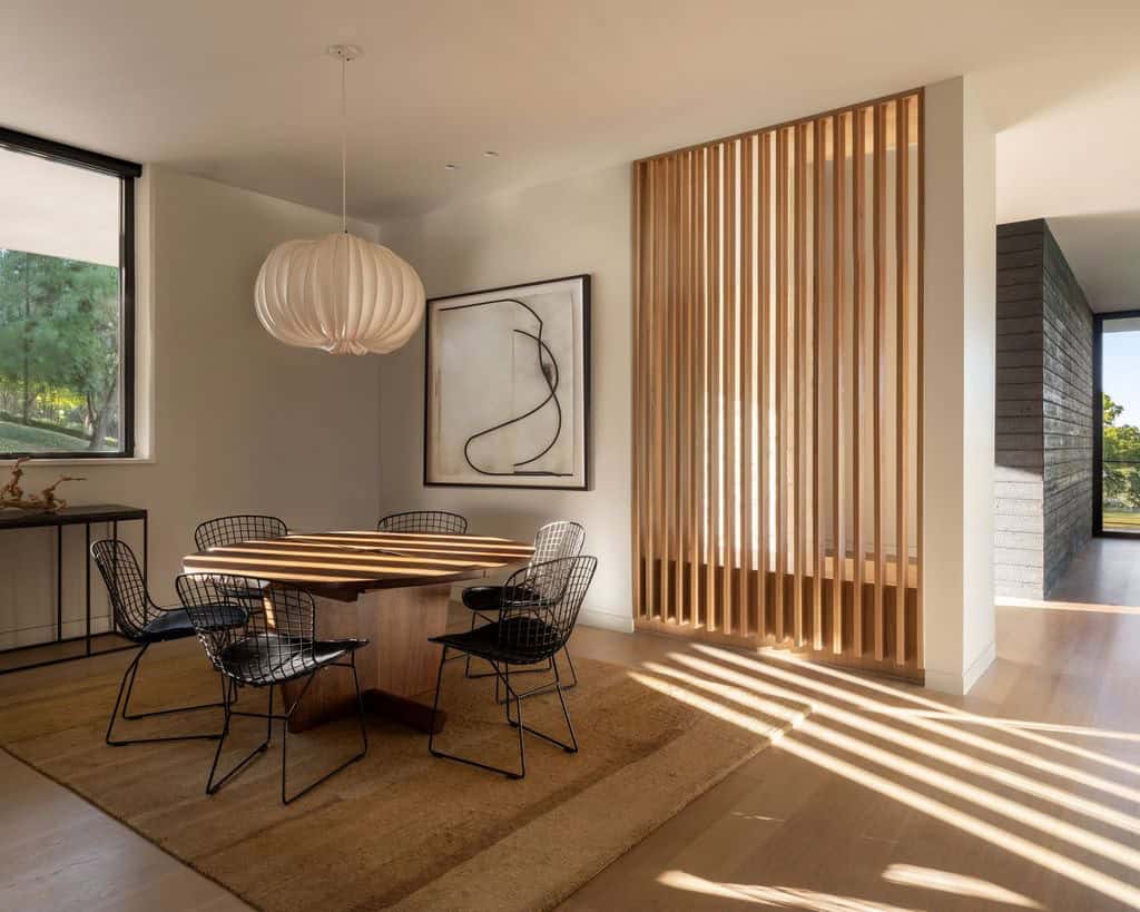 Dining room with round table and wood slat screen