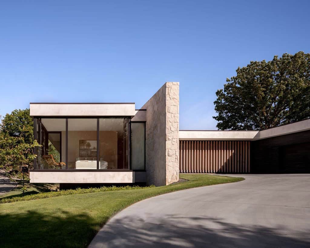 Primary bedroom glass box with stone wall at sunset