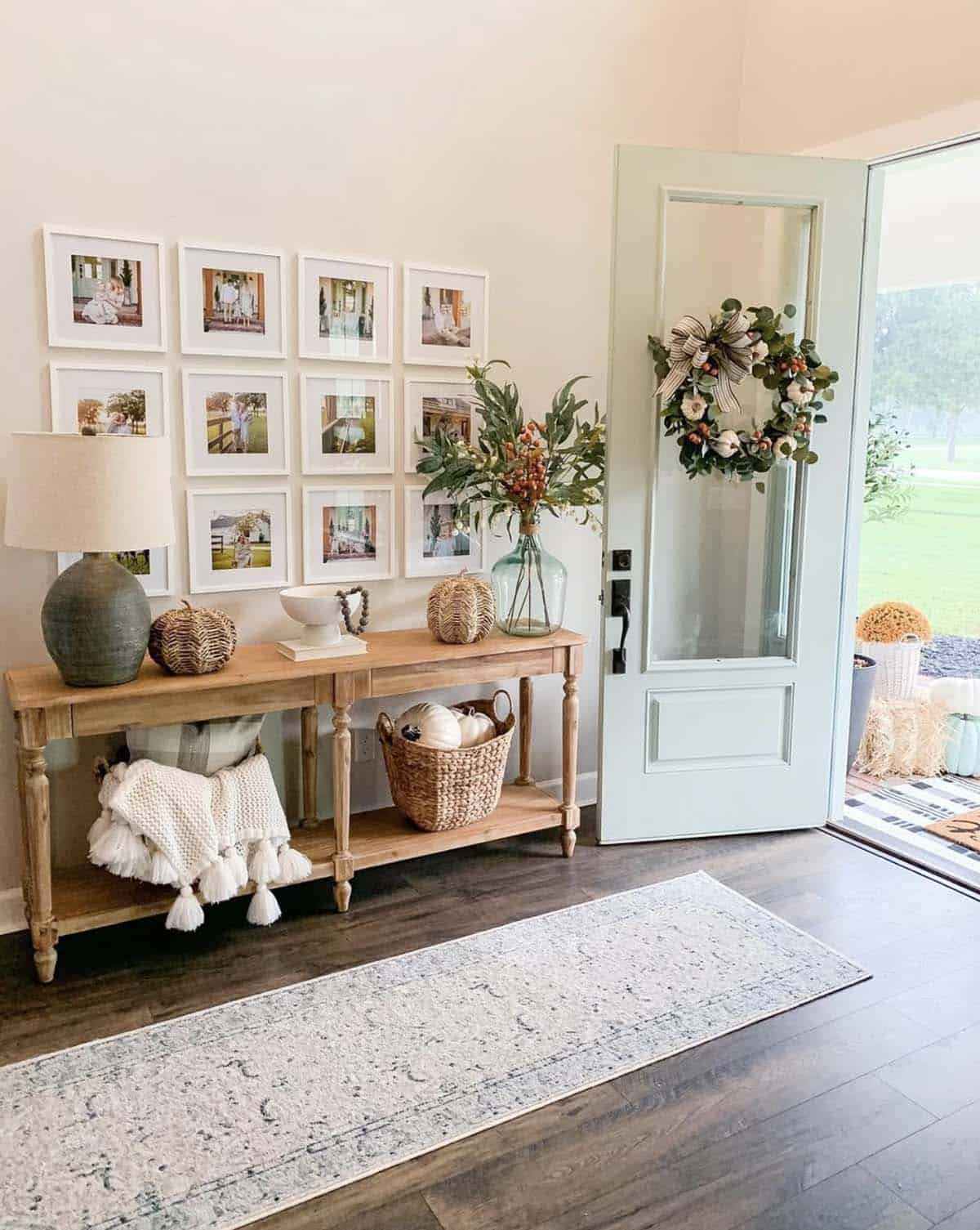 Front door with a fall wreath beside a styled console table