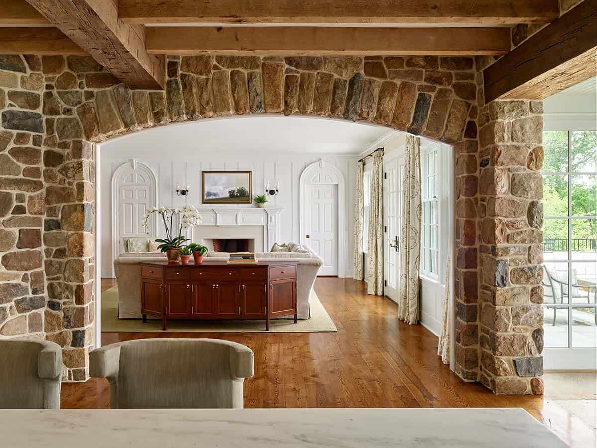 Stone archway frames a view into the paneled living room