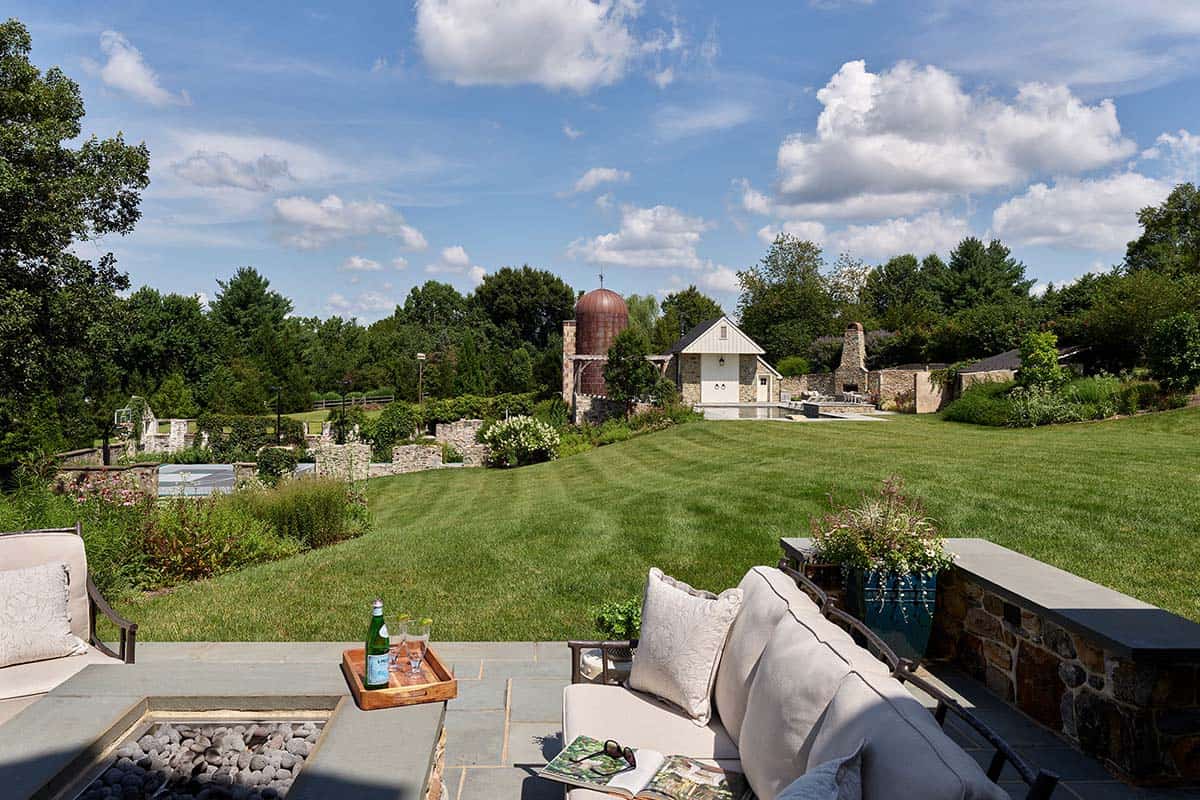 Patio fire pit overlooking lawn, pool house, and copper silo