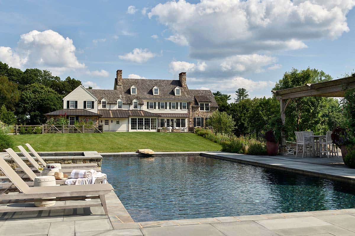 Rear view of the farmhouse across the pool and lawn