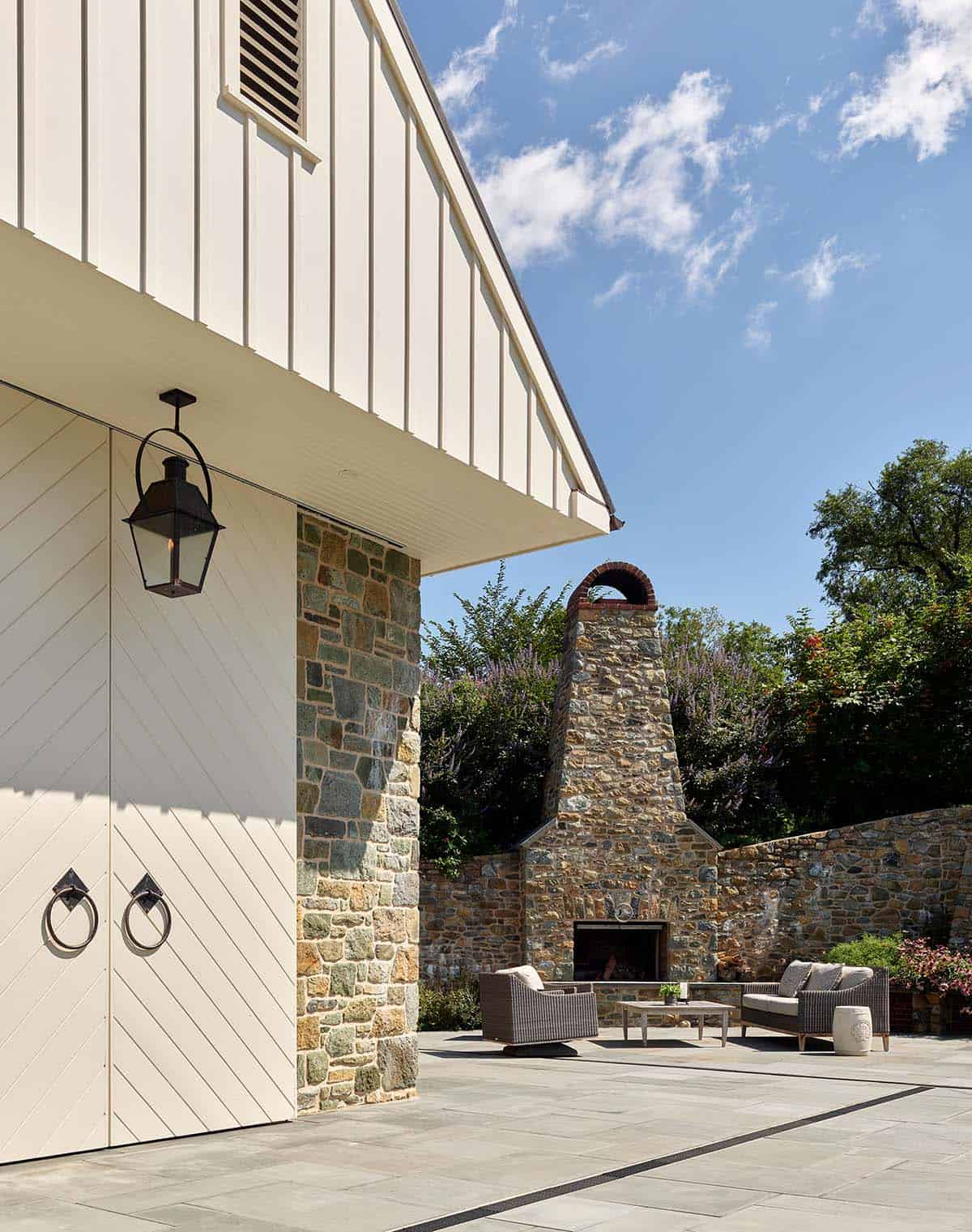 Stone pool house exterior with lantern and outdoor fireplace