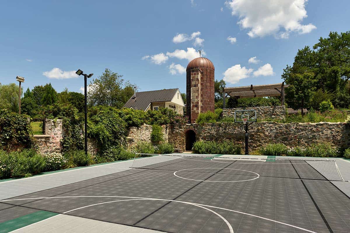Backyard sport court enclosed by stone walls near the silo