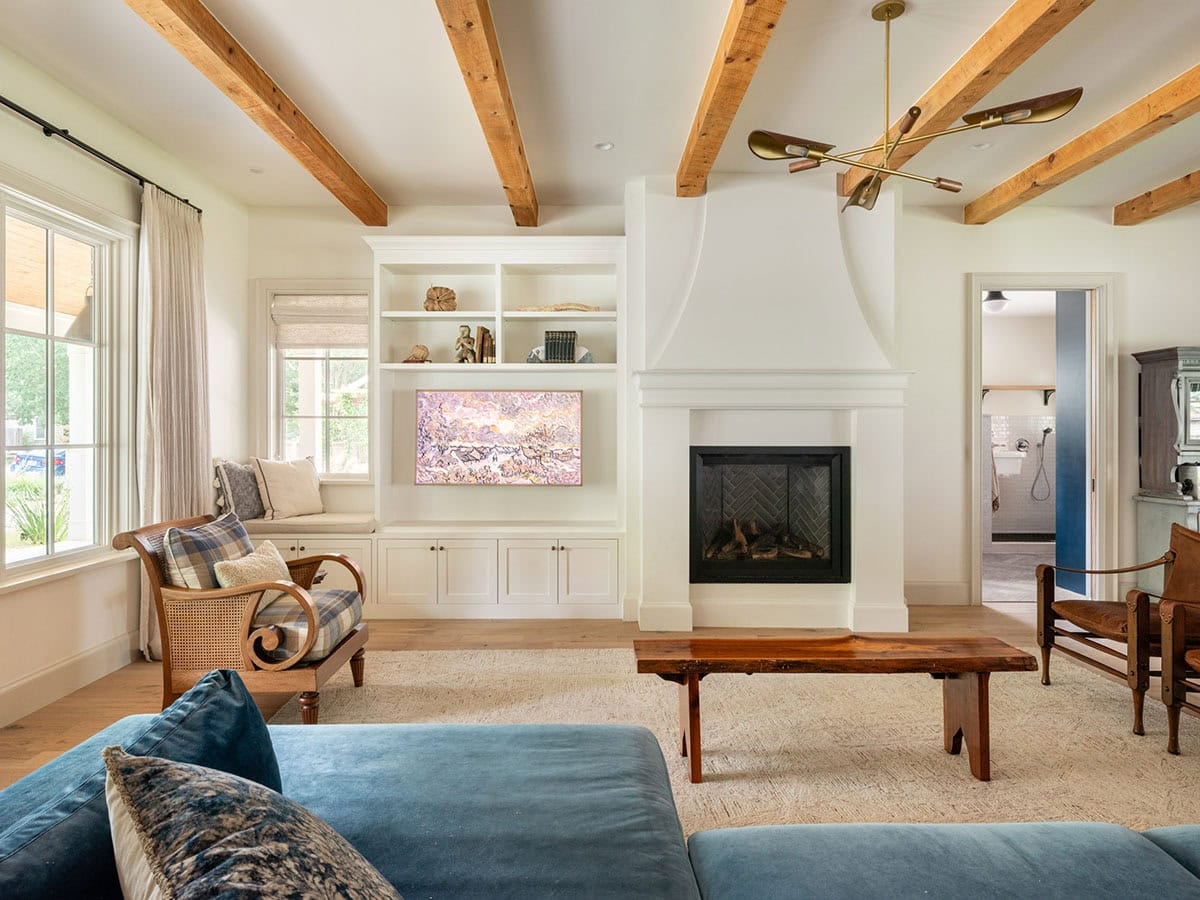 Living room with exposed wood beams and blue velvet sectional