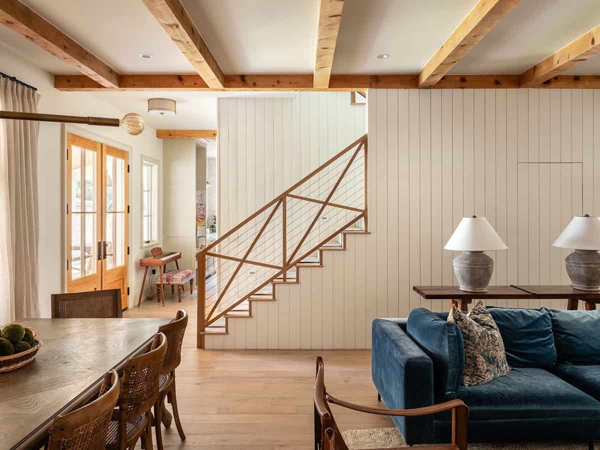 Open staircase with cable railing beside dining and living space