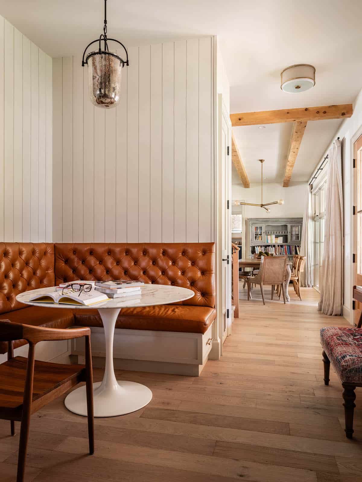 Leather banquette nook overlooking dining room and library beyond