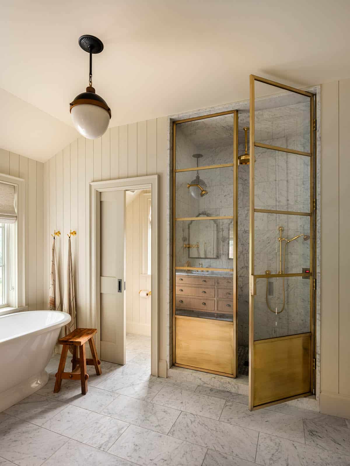 Primary bathroom with antique mirrored glass shower and brass fixtures