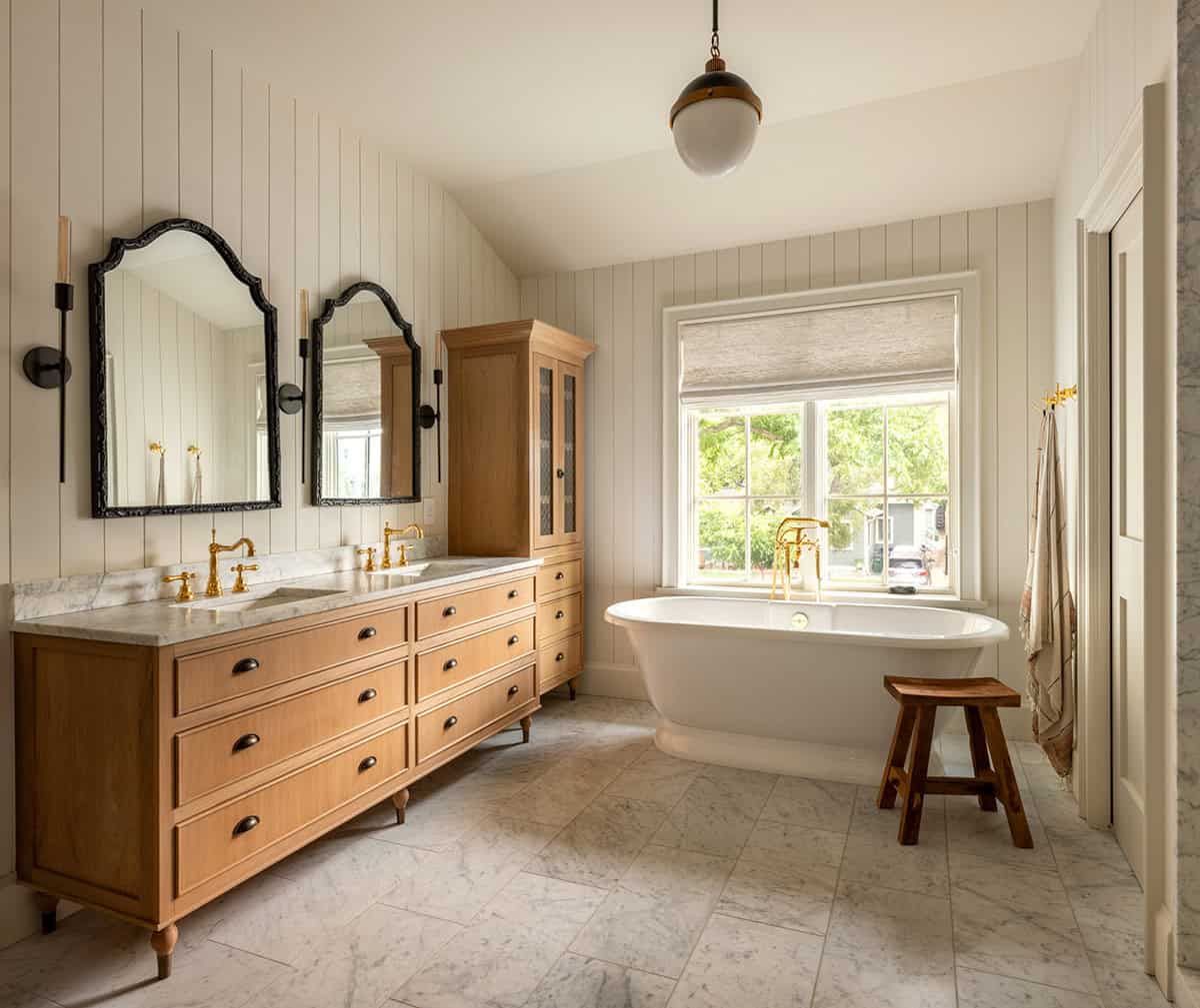 Double vanity bathroom with oak cabinetry and arched black mirrors