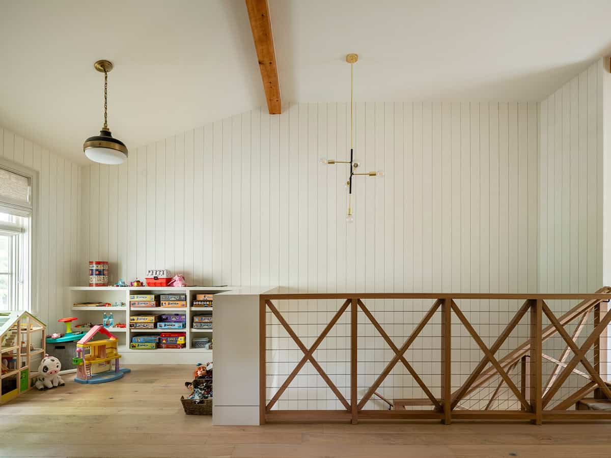 Playroom loft with wood beam, brass pendant, and X railing