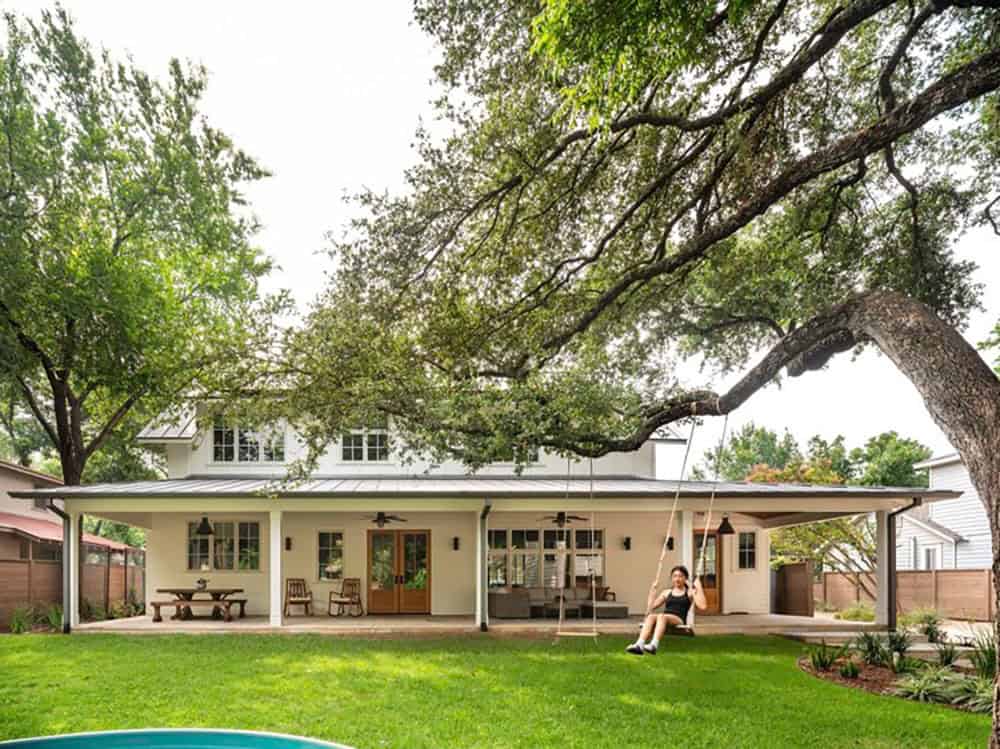 Backyard porch with pool, rocking chairs, and girl on swing