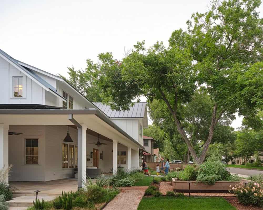 Farmhouse front porch and yard with family walking the path