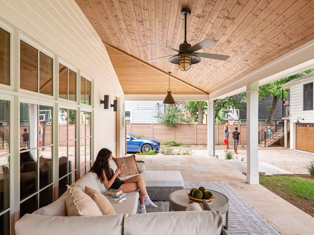 Covered patio with wood ceiling fan overlooking driveway and yard