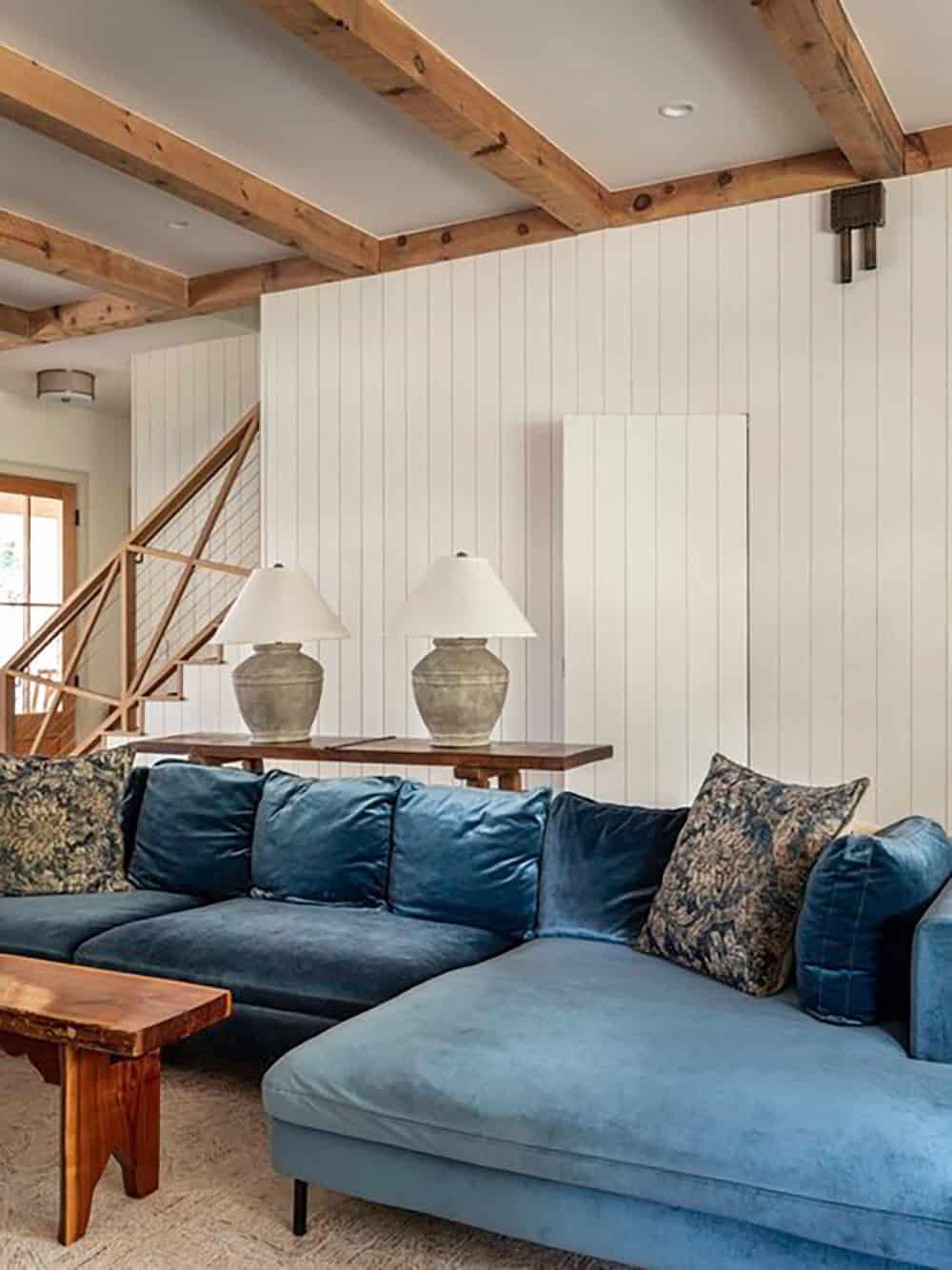Living room with wood beams and teal blue velvet sofa