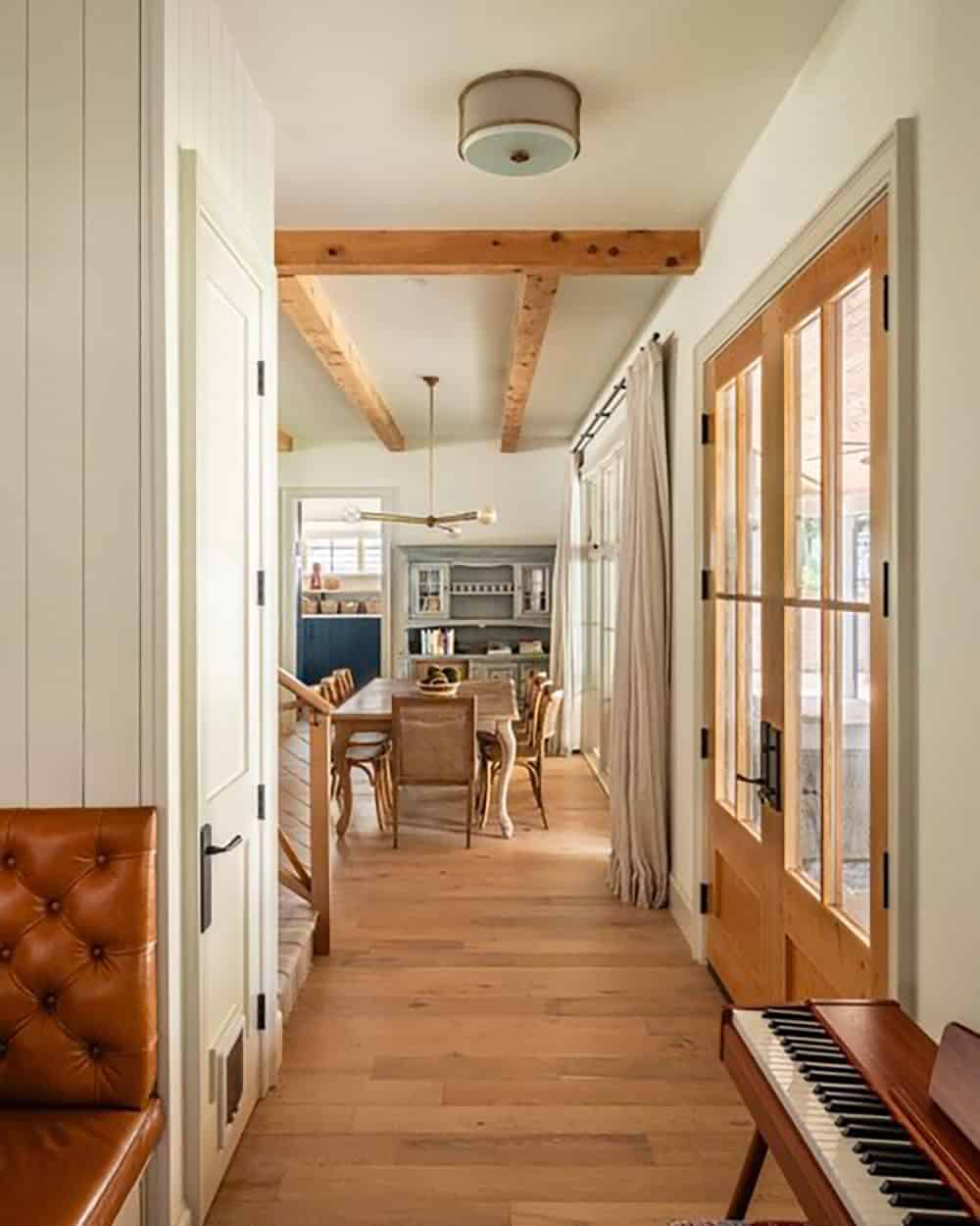 Hallway view toward dining room with French doors and piano