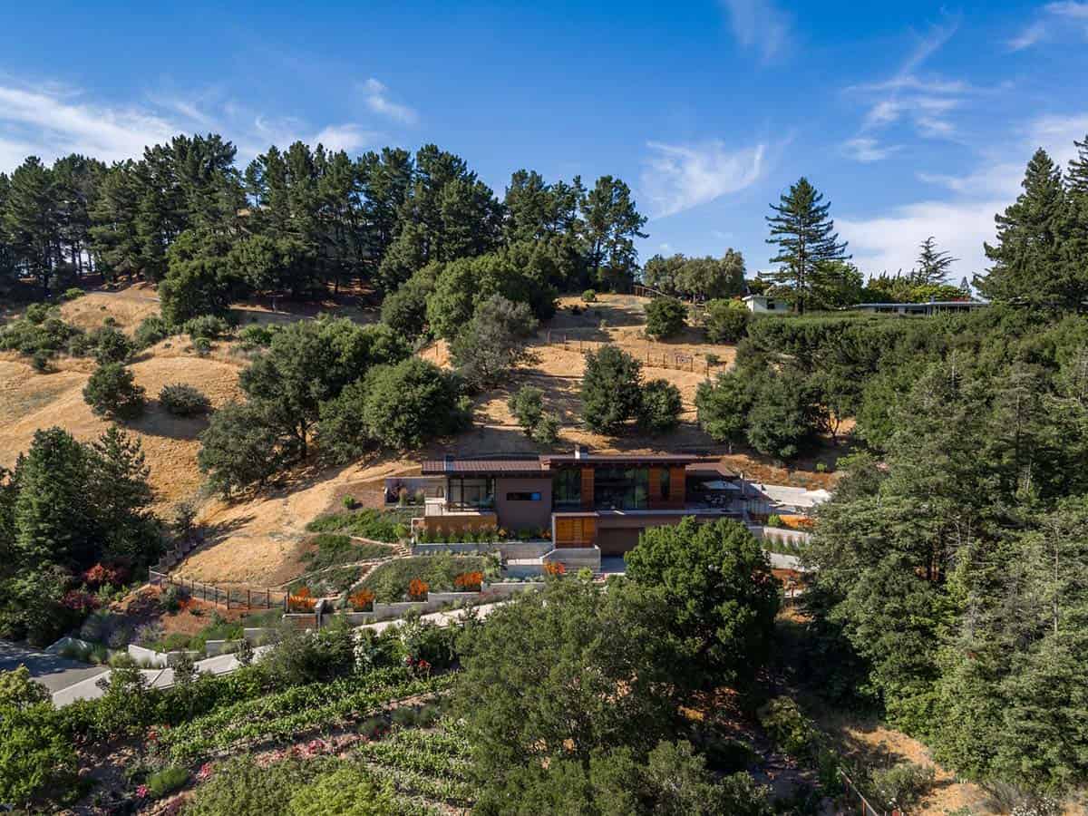 Modern home nestled into oak-studded hillside with sweeping valley views beyond