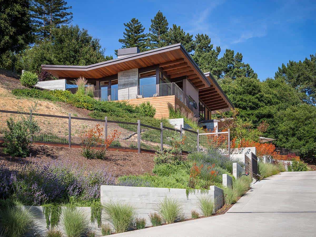Terraced hillside landscaping leads up to home's expansive wood eave and deck