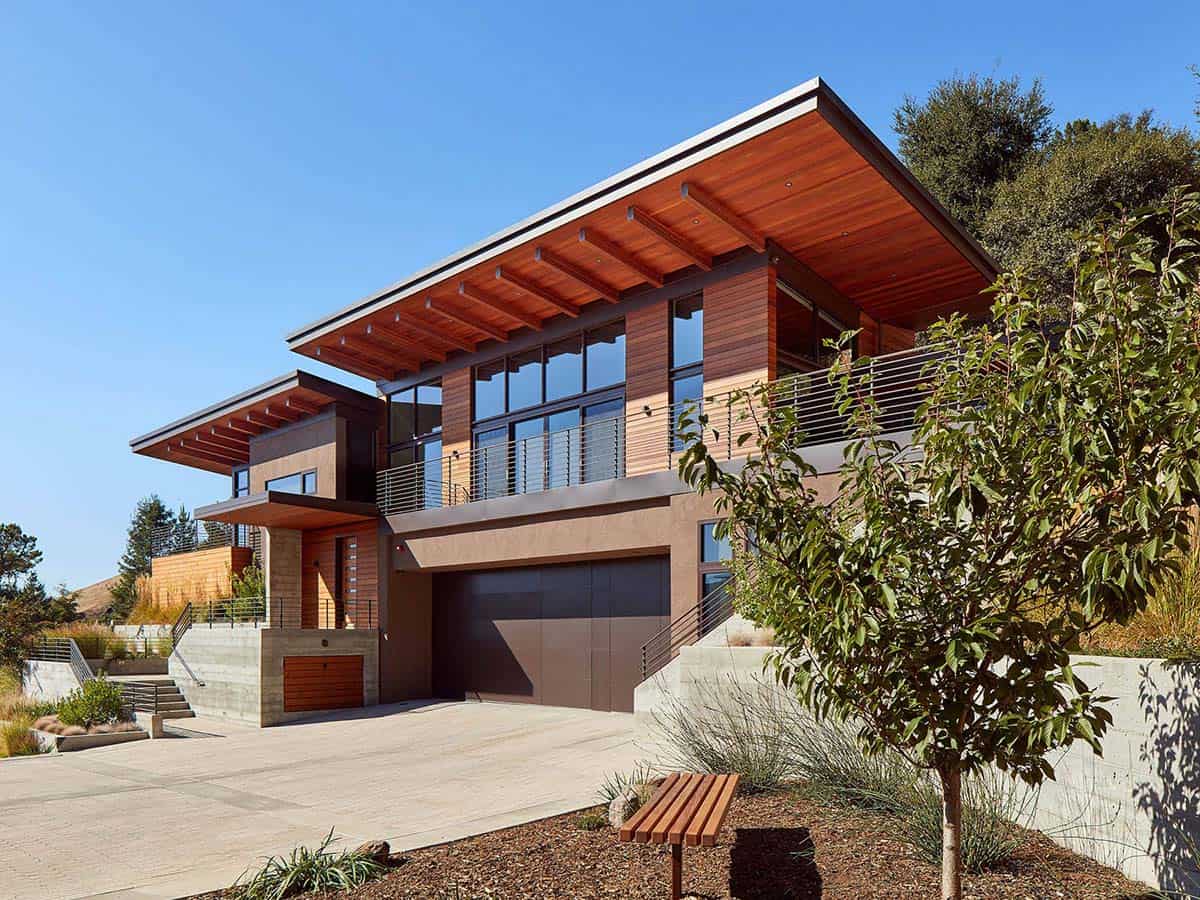 Two-story exterior showcases wood siding, concrete base, and deep roof overhangs