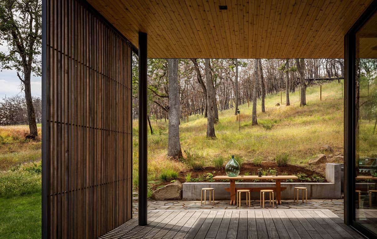 Covered outdoor dining area with cedar ceiling and slatted wood screen