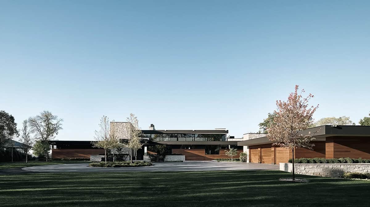 Modern lake house exterior with stone chimney and wood siding