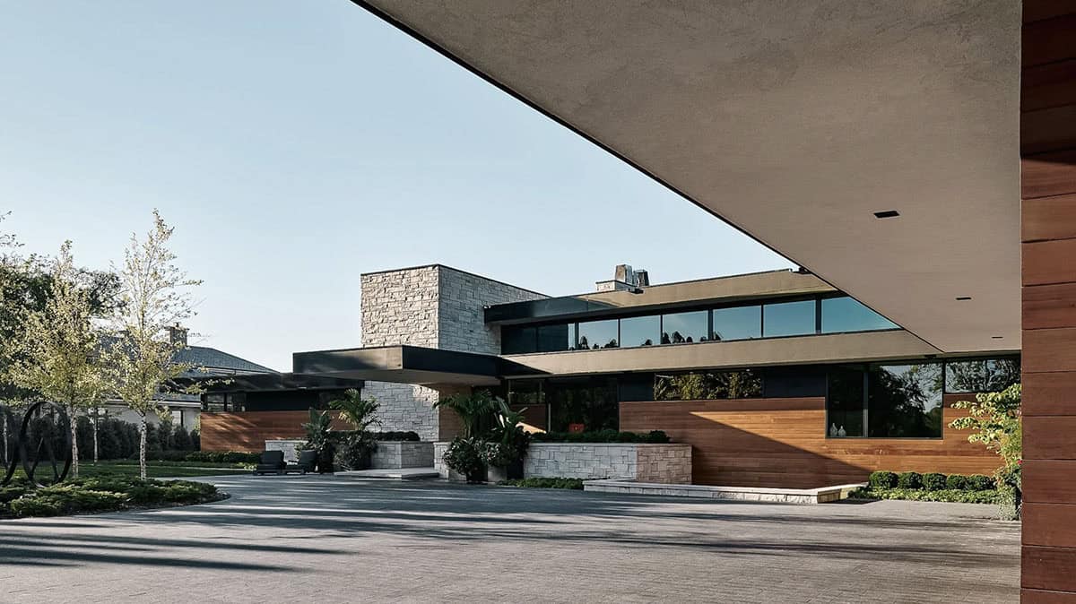 Cantilevered roofline shading the stone and wood entry facade