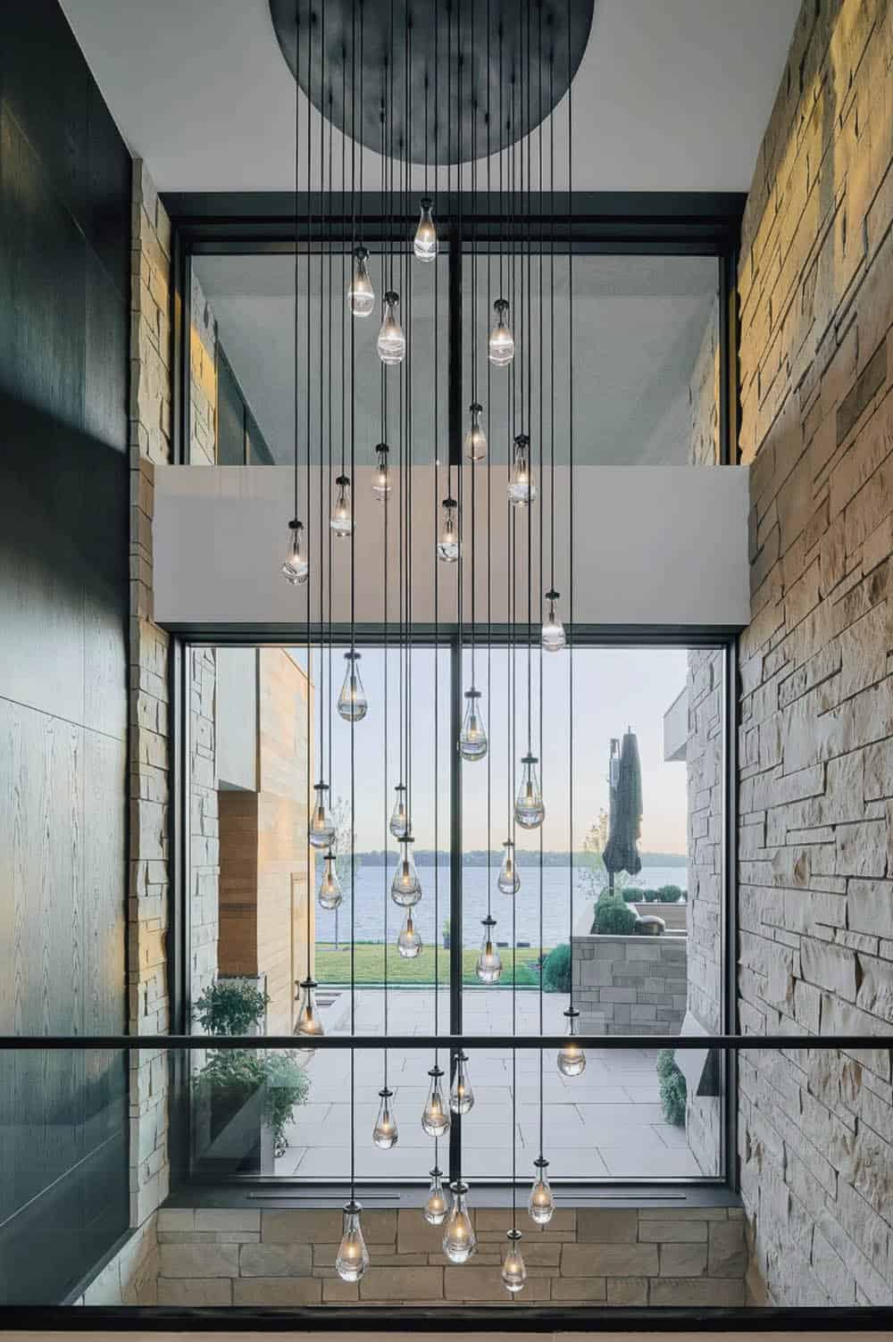 Teardrop glass pendant chandelier cascading past the stairwell window