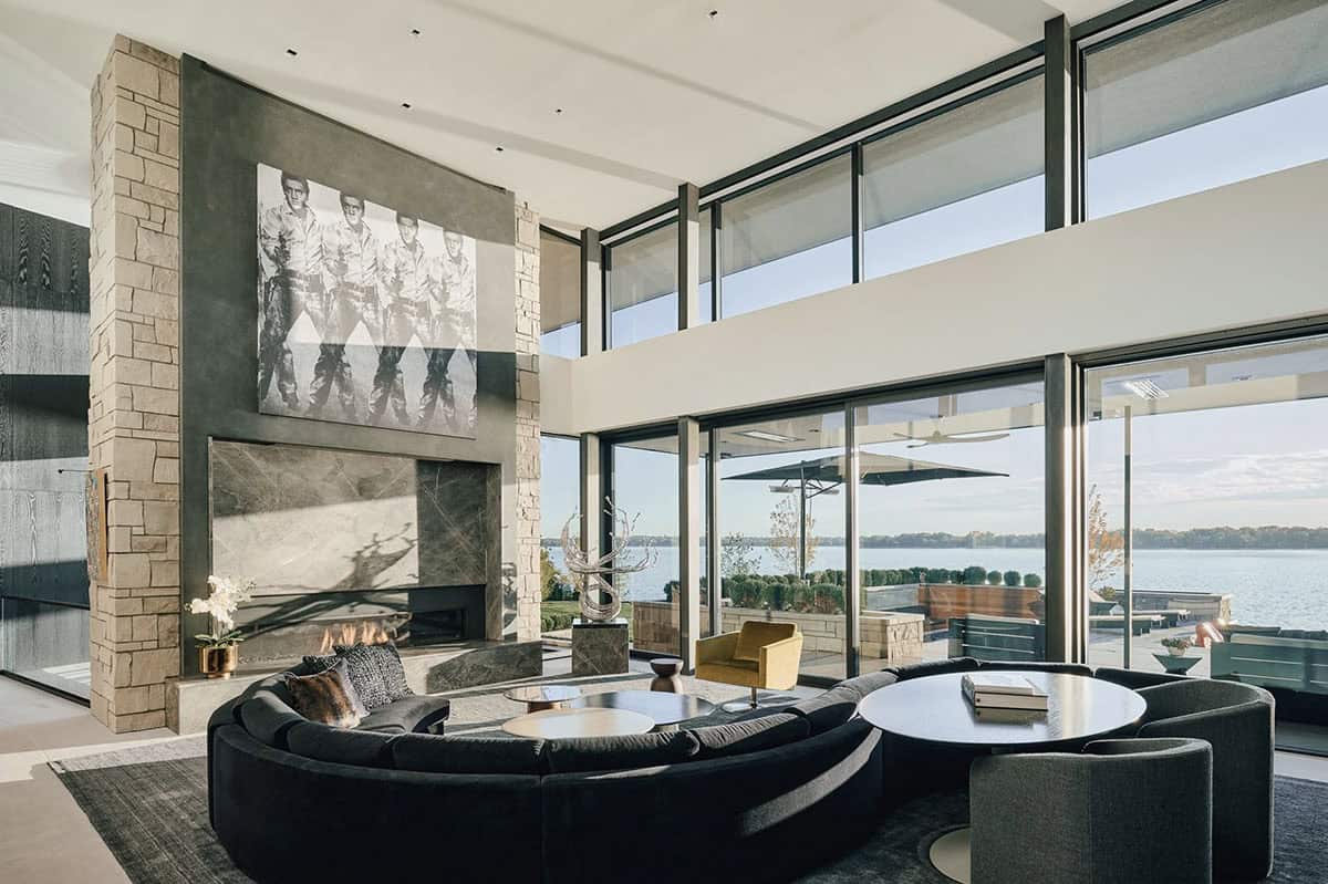 Living room seating around the fireplace with lake views beyond