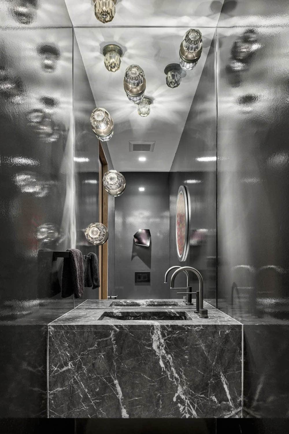  Powder room with mirrored walls and cluster of glass pendant lights
