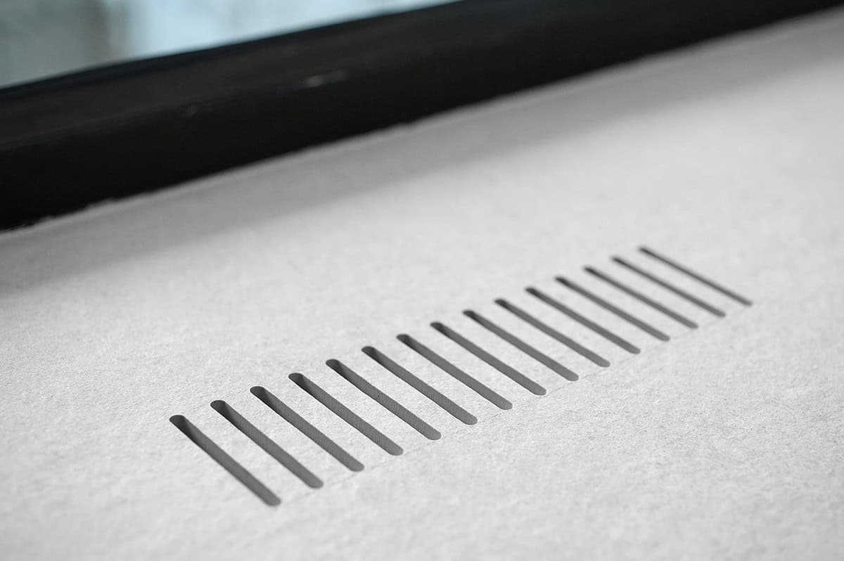 Detail of vented panel edge with black framed glass beyond