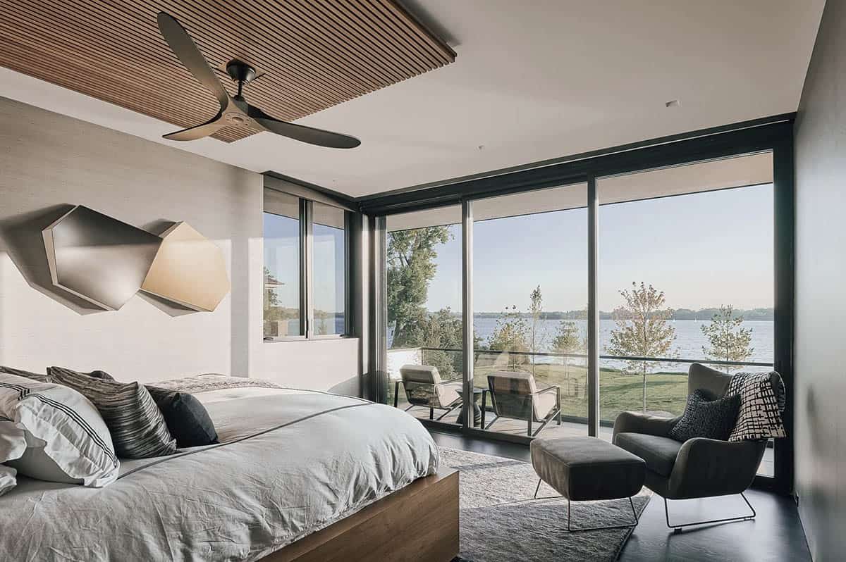 Primary bedroom with slatted wood ceiling and lake view balcony