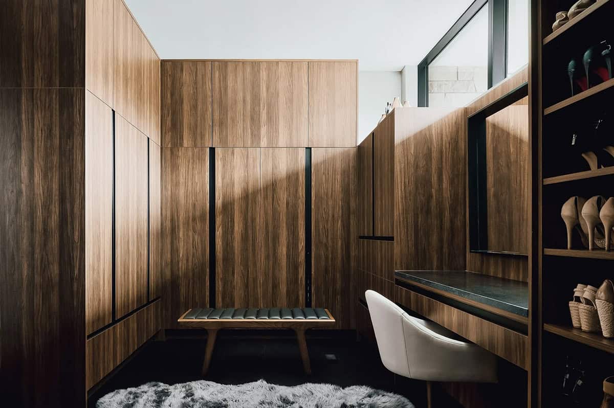 Walk in closet with walnut cabinetry and vanity nook