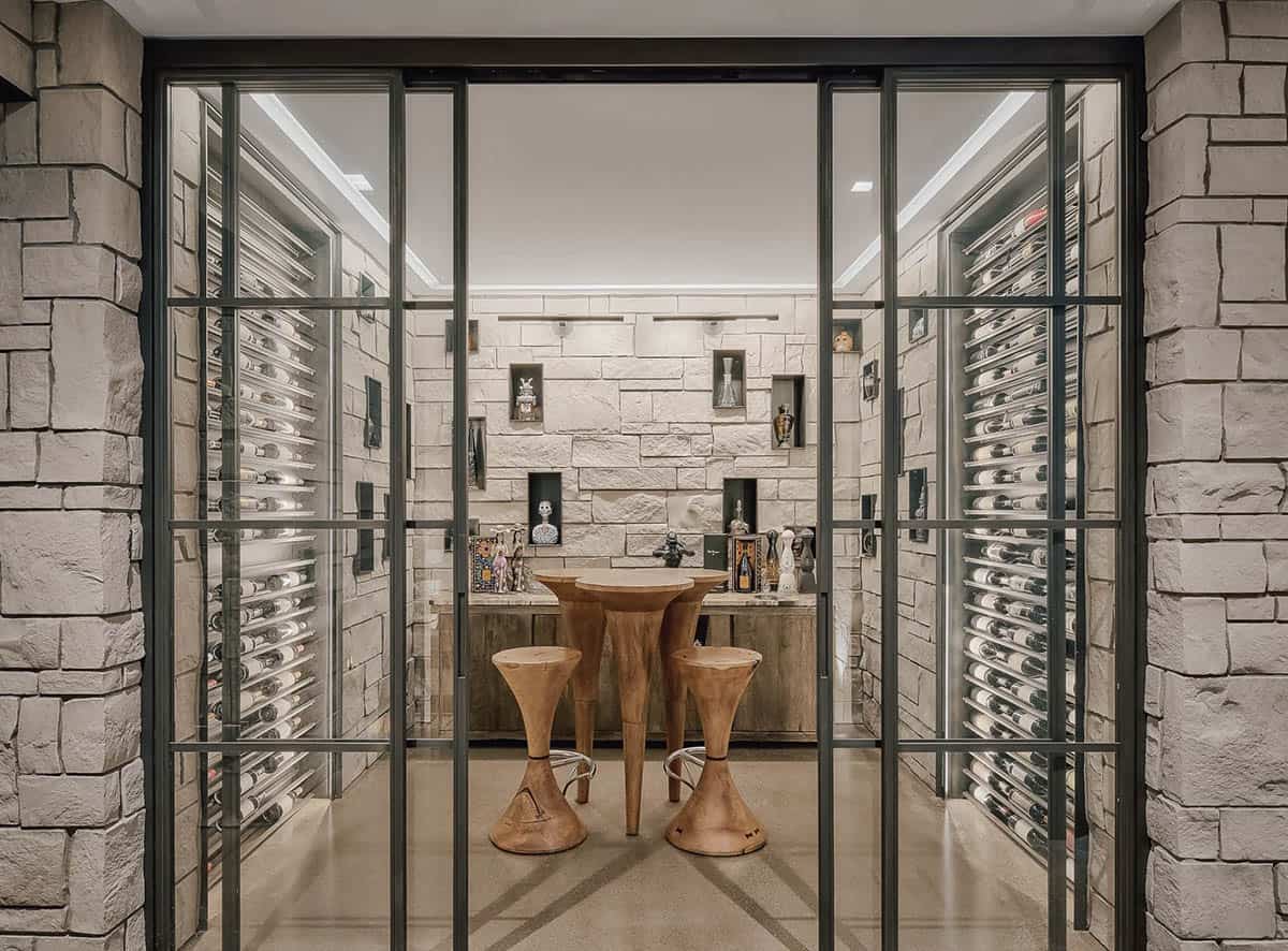 Glass enclosed tequila tasting room with stone walls and table