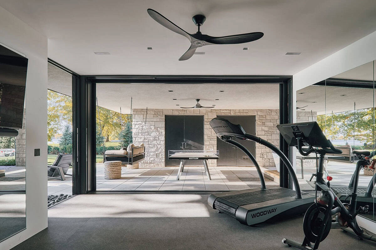 Home gym opening to a covered patio with ping pong table