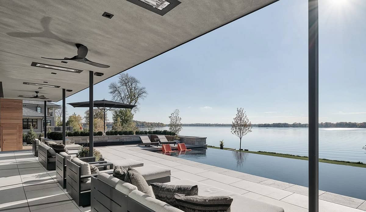 Covered patio lounge overlooking the infinity edge pool and lake