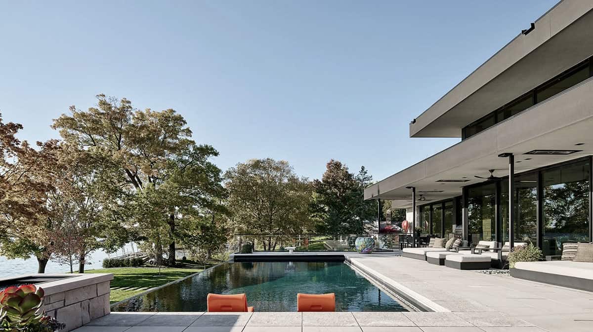 Infinity pool with orange loungers stepping down to the lake