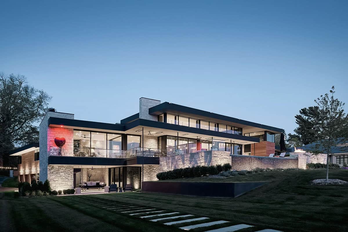 Twilight exterior of the lake house with illuminated stone facade