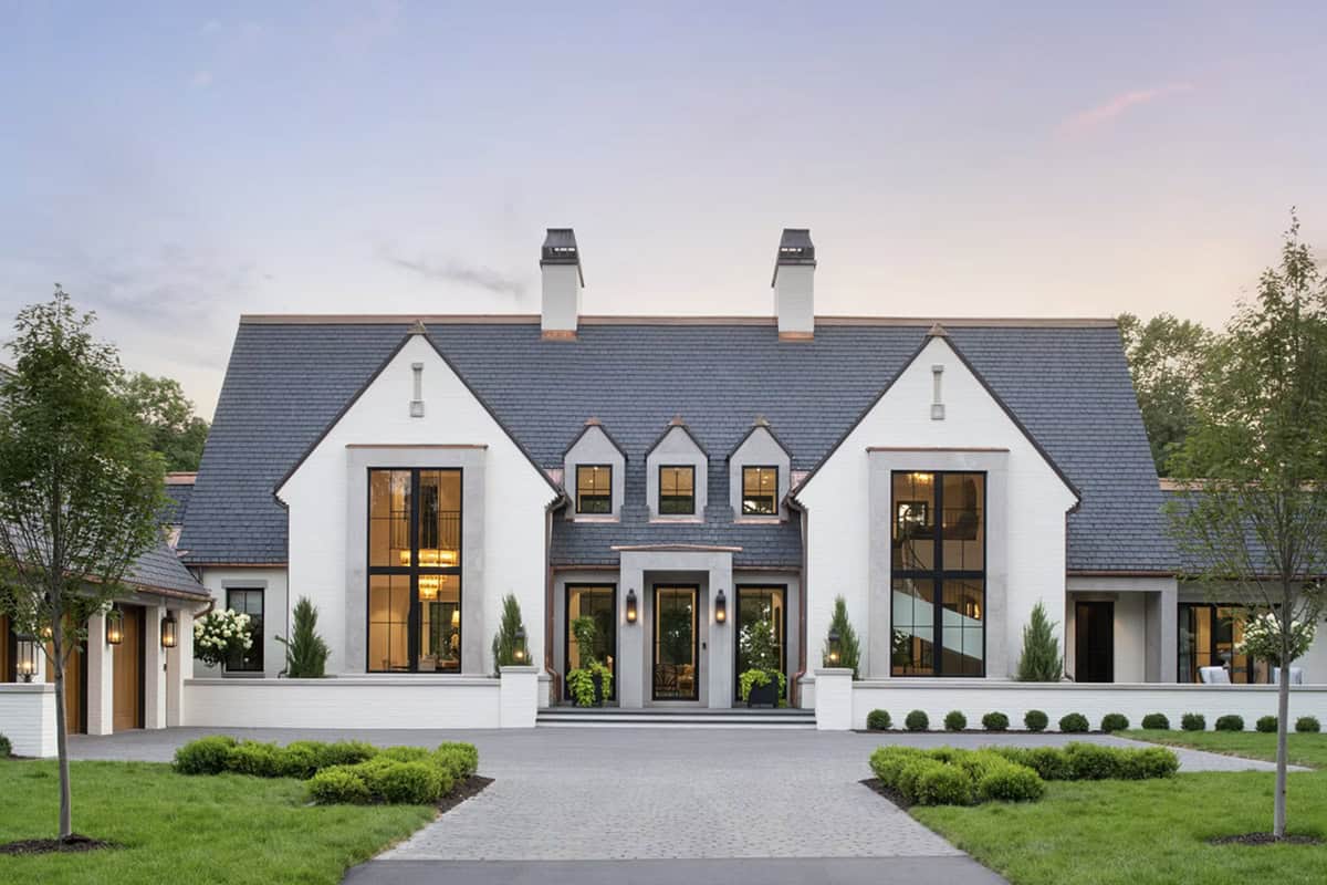 Twilight view of white brick facade with black steel windows