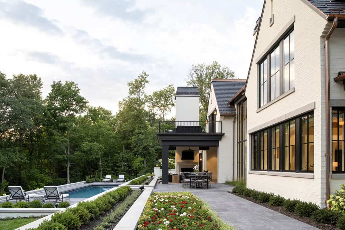 Rear pool terrace with black steel columns and outdoor fireplace