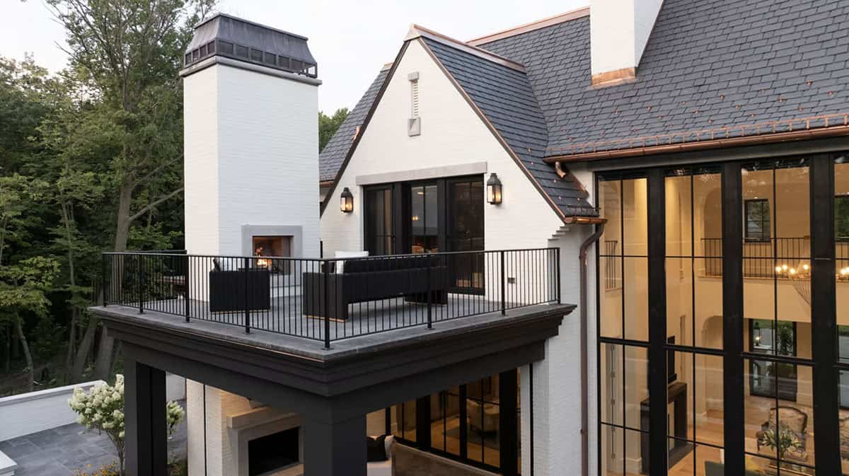 Rooftop balcony with fireplace and black steel railing at dusk