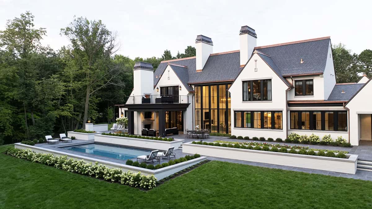Rear elevation with pool, chimneys, and layered gabled rooflines