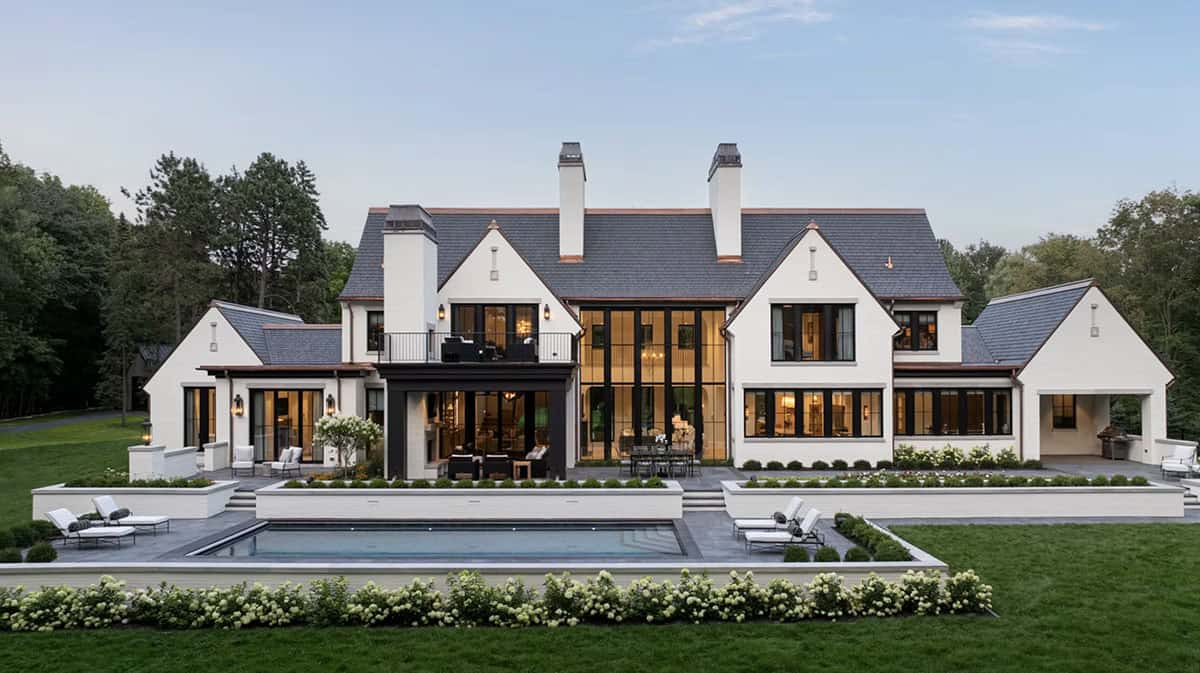 Twilight view of rear facade with pool and glass great room