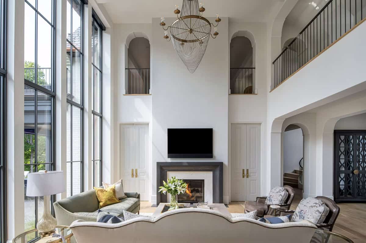 Great room fireplace flanked by arched niches and iron railing
