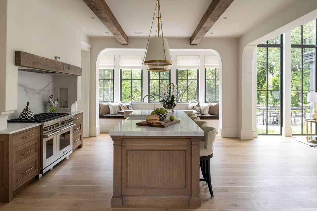 Kitchen island facing arched breakfast nook with built-in bench