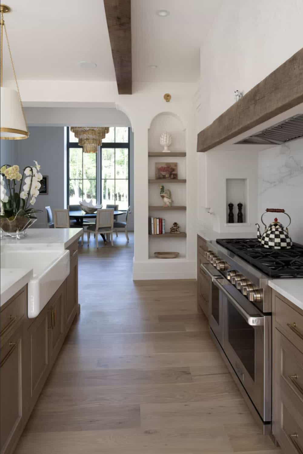 Galley kitchen with built-in display shelving and marble backsplash niche