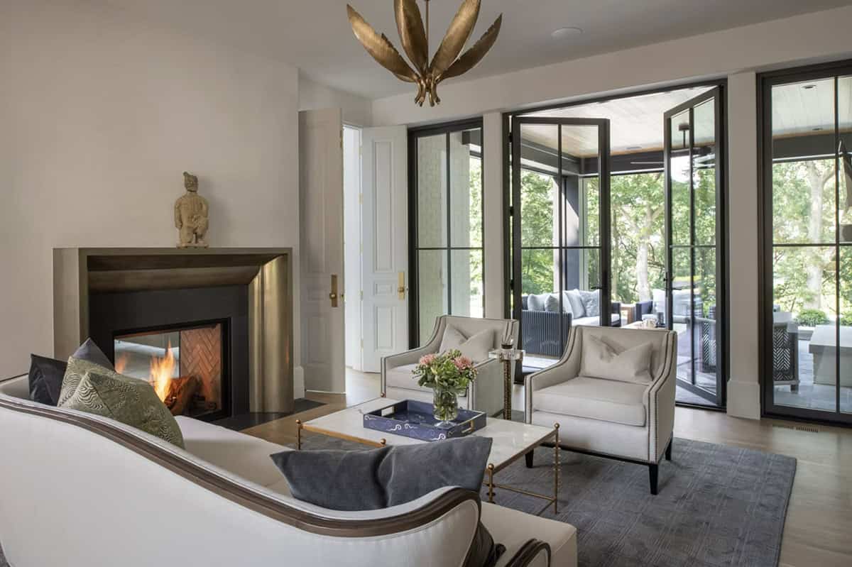 Sitting room with brass fireplace opening to screened porch