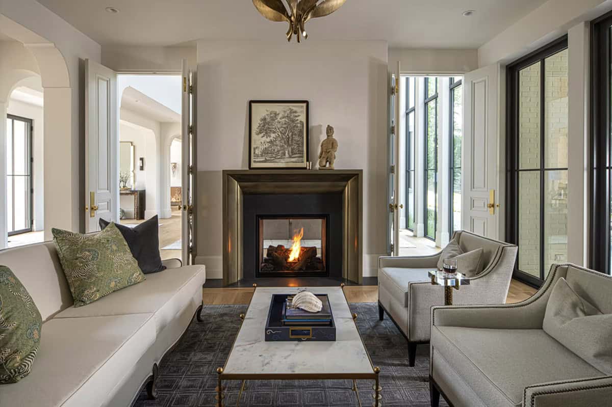 Sitting room fireplace flanked by antique bronze mantel surround